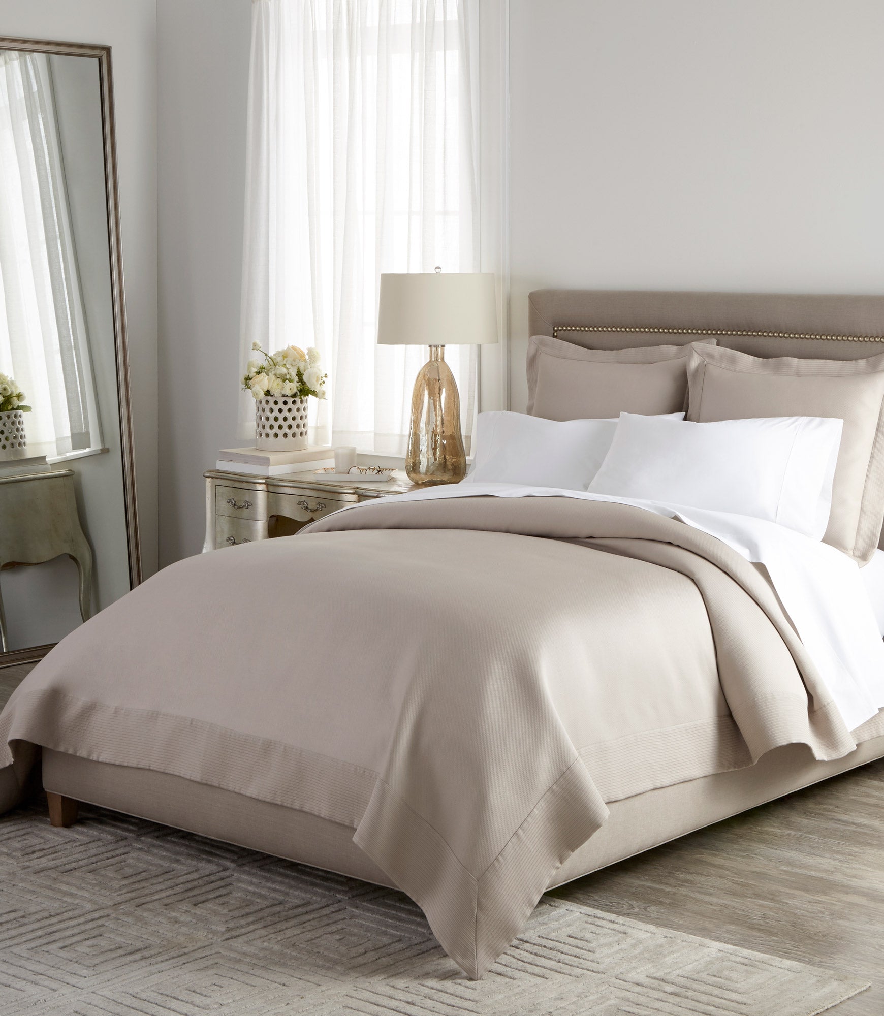 Angelina Platinum Coverlet and Shams on a neutral upholstered bed