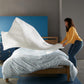 woman putting White 4 square quilted coverlet on bed