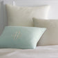 Mandalay Decorative Pillows On Bed Lagoon Linen Pearl Colors