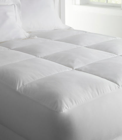 Down alternative mattress topper and mattress cushion on a bed White