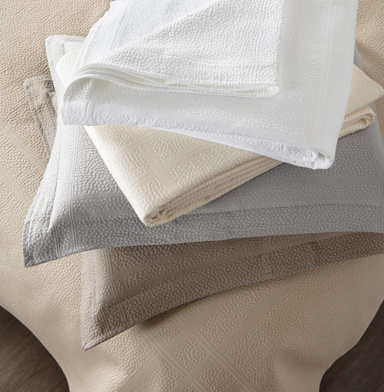 messy stack of folded Montauk shams coverlets in various colors White Pearl Linen Gray Platinum