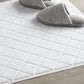 White slippers on top of lattice bath rug