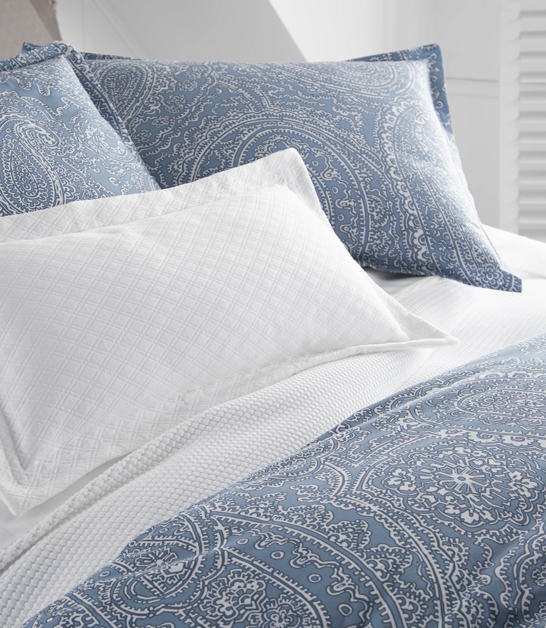 Blue coastal paisley duvet cover and shams on bed detail