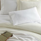 Virtuoso Sateen Sheet Set Ivory and White on a Bed