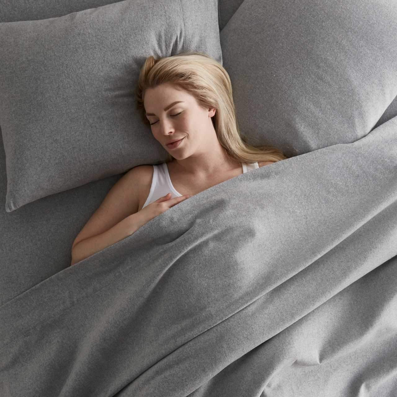 woman laying in Light Gray flannel sheets