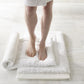 woman standing on white memory foam bath rug White